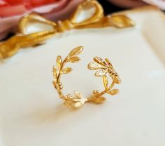 A lovely open Laurel wreath ring features small leaves wrap around your finger. Ring is adjustable to fit any size.  Ring is brass with gold plating. Enjoy! Purchase over $40 enjoys free shipping! Coupon code 'freeshipping1'. Free Gift Wrapping on request - All items that are gift wrapped come in with a kraft box with raffia string and blank writing card.  Please leave a note if you need it upon ordering. Laurel Ring, Laurel Wreath Ring, Gold Leaf Ring, Wreath Ring, College Rings, Botanical Ring, Ring Wreath, Wreath Rings, Gold Leaf Rings