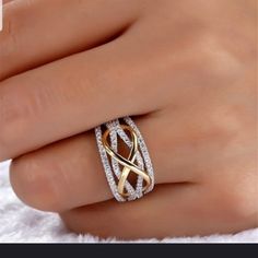 a woman's hand with a gold and white diamond ring on her left hand