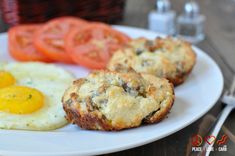 an egg muffin and some tomatoes on a white plate