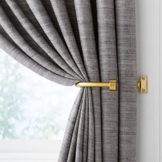 a curtain with a gold handle on it next to a window