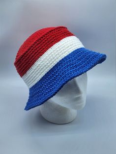 a white mannequin head wearing a red, white, and blue crochet hat