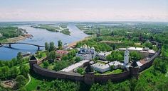 an aerial view of a castle in the middle of a forest with a river running through it