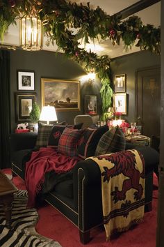 a living room filled with furniture covered in christmas decorations and greenery hanging from the ceiling