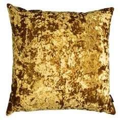 a gold velvet pillow on a white background