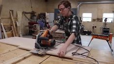 a woman using a circular saw to cut wood