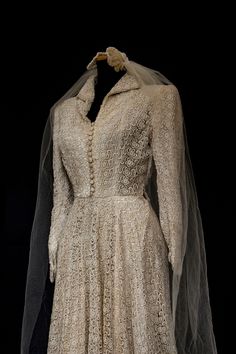 an old wedding dress with a veil on it's head and neckline is displayed