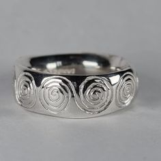 **Please note that we dispatch on Tuesdays unless special delivery express option is paid for** Sterling silver 'spirals' ring. Original design carved in wax then lost wax cast into solid sterling silver. This is a large and chunky ring, with a very rounded super smooth interior. It glides on like a silky glove. Item weighs approximately 12g in silver.  Band width 7.5mm Band thickness 3-3.5mm (uneven, and undulating thickness) First class recorded post included. Handmade Silver Band Ring, Cheap Handmade Silver Rings, Cheap Handmade Metal Rings, Chunky Silver Rings Men, Lost Wax Casting Rings Design, Unique Spiral Rings For Anniversary, Silver Spiral Sterling Silver Ring, Spiral Sterling Silver Rings, Silver Spiral Ring For Anniversary