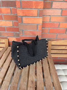 a black purse sitting on top of a wooden bench