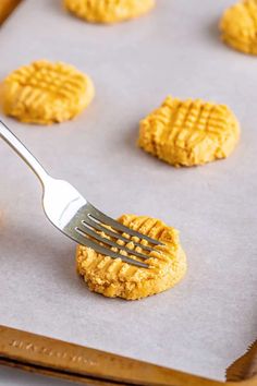 a fork is stuck into some cookies on a baking sheet