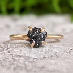 a black diamond ring sitting on top of a rock