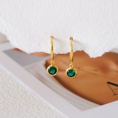 Add a touch of vibrant elegance to your jewelry collection with these Dainty Emerald Huggie Earrings. Featuring tiny emerald stones set in high-quality sterling silver, these hoops offer a rich green hue that symbolizes renewal and growth, making them perfect as a birthstone gift for those born in May or for anyone who loves the timeless beauty of emeralds. The dainty, huggie-style design ensures a comfortable fit, ideal for everyday wear or special occasions. Whether as a thoughtful gift for he Green Sterling Silver Small Hoop Earrings, Elegant Green Huggie Jewelry, Anniversary Huggie Earrings With May Birthstone, Anniversary Gift May Birthstone Round Huggie Earrings, Minimalist Round Hoop Earrings With Birthstone, Gold Hoop Earrings With Birthstone - Fine Jewelry, Small Hoop Green Earrings For May Birthstone, Gold Hoop Earrings With Birthstone, Hoop May Birthstone Jewelry Gift