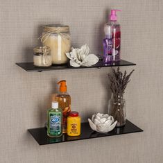 two black shelves with bottles and soaps on them, one shelf is holding an empty bottle