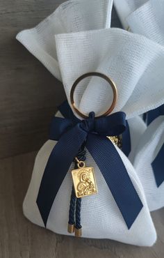 a white bag with a blue ribbon tied around it and a gold key hanging from the front