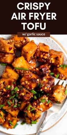 crispy sesame tofu on a plate with chopsticks and green garnish