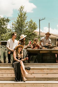 a group of people sitting on top of wooden steps