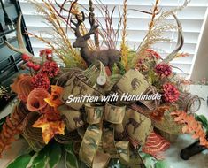 an arrangement of fall foliage and deer heads is featured in the front of a window