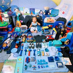 a child is sitting on the floor surrounded by toys and other items that are scattered around him