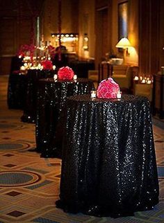 black sequin tablecloths with candles and flowers on them in the middle of a banquet hall