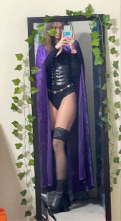 a woman dressed as a witch taking a selfie in front of a mirror