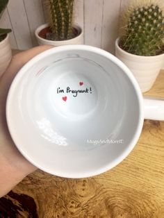 a person holding a white bowl with the words i'm proud written on it