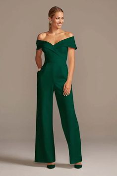 a woman in a green jumpsuit posing for the camera with her hands on her hips