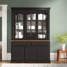 a black china cabinet with glass doors and drawers