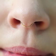 a woman's nose with a gold nose ring on it