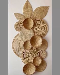 several woven baskets are arranged on the wall, with leaves and circles around them in varying sizes