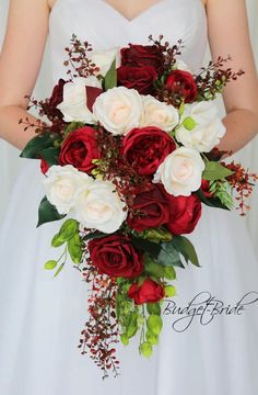 a bride holding a bouquet of red and white flowers