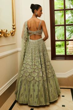 Mint green attached cancan flared lehenga with all-over scallop spark tonal embroidery highlighted with sequin, silver beads and crystals. Paired with sweetheart neck cut out detail embellished sleeveless padded blouse and scallop embroidered net dupatta.
Components: 3
Pattern: Embroidery
Type Of Work: Tonal Silver Beads, Sequins, Crystals
Neckline: Sweetheart Neck
Sleeve Type: Strap Sleeves
Fabric: Net, Raw Silk
Color: Green
Other Details: 
Attached cancan
Padded blouse
Blouse with bead drops
A Elegant Green Lehenga With Intricate Embroidery, Green Hand Embellished Anarkali Set, Hand Embellished Green Anarkali Set, Elegant Green Choli With Intricate Embroidery, Green Hand Embellished Traditional Sharara, Green Lehenga For Reception, Festive Green Hand Embellished Choli, Green Hand Embellished Dupatta In Traditional Drape, Semi-stitched Green Hand Embellished Dupatta