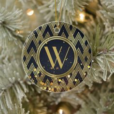 an ornament hanging from a christmas tree decorated with gold and black geometric designs