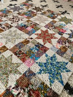 a multicolored quilt is laying on the floor