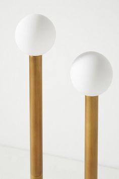 two white and gold lamps on top of each other