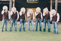 a group of men in cowboy hats standing next to each other on top of grass