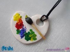 a necklace that has been painted with paintbrushes and flowers on the front, along with a black bead cord