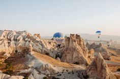 several hot air balloons are flying over the rocky landscape in cappads, turkey