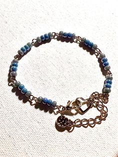 Pretty dainty sky blue glass seed bead bracelet, with lobster claw clasp. Also includes textured charm. This bracelet is made by linking together beaded wire creating a unique look. Great gift for your friend, wife, daughter, or anyone special in your life. Adjustable; fits 6.5-7.5 inch wrist, clip the clasp to heart or on any link for convenient adjustment. Two additional days needed for any special requests. Message me for more info. Adjustable Czech Glass Jewelry With Tiny Beads, Adjustable Metal Beaded Bracelet In Dainty Style, Adjustable Czech Glass Bracelets With Tiny Beads, Adjustable Beaded Bracelets With Lobster Clasp For Everyday, Dainty Blue Adjustable Beaded Bracelets, Dainty Adjustable Blue Beaded Bracelets, Dainty Blue Bracelets With Tiny Beads, Dainty Blue Friendship Bracelets With Tiny Beads, Dainty Blue Friendship Bracelet With Tiny Beads