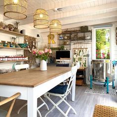 a table with chairs in a room next to shelves and baskets on the wall above it