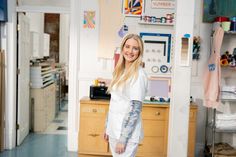 a woman standing in a room with lots of clutter