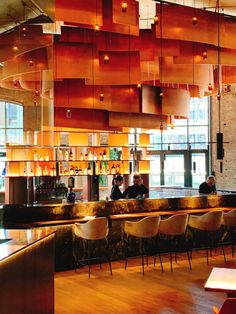 the interior of a restaurant with people sitting at the bar