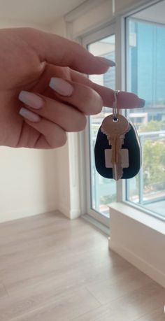 a woman's hand holding a key to a window