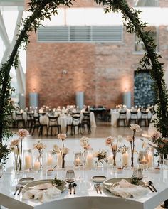 a table set up with candles and flowers in vases for an elegant wedding reception