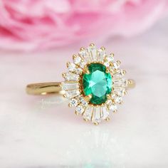 Beautiful Vintage Inspired Emerald Ring ►Base Metal: Sterling Silver (925) ►Plating: 14K Yellow Gold ►Accented With Simulated Diamonds (CZ) ►Average band width: 1.7 mm. ►Style: Art-Deco Center Stone: Emerald Gemstone Creation: Simulated Stone Shape: Oval Gem size: 7.0 x 5.0 mm Carat Weight: 0.76 ct. (Approx.) ✓ 100% Nickel-Free ✓ Hypoallergenic ✓ Comfort Fit ✓ Free Ring Box ✓ Free USA Shipping ►Please be aware that plated jewelry can wear off over time, if this is a concern we would suggest goin Timeless Cubic Zirconia Emerald Ring For Anniversary, Emerald Ring With Center Stone In Baguette Cut, Emerald Ring With Baguette Cut Center Stone, Classic Diamond Ring With Accent Stones For May Birthstone, Timeless 14k Gold Emerald Wedding Ring, Emerald Baguette Cut Ring With Center Stone, Heirloom Emerald Ring With Halo Setting, Emerald Cluster Ring With Halo Design For Promise, 14k Gold Art Deco Ring With Center Stone