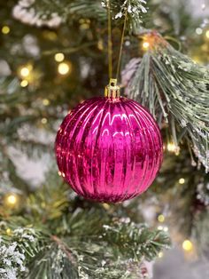 a pink ornament hanging from a christmas tree