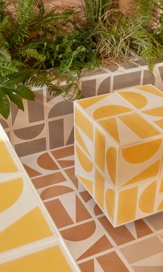 two yellow and white cubes sitting next to each other on top of a tiled floor