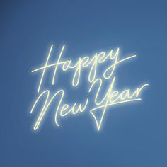 a neon sign that says happy new year against a blue sky with the words written below it