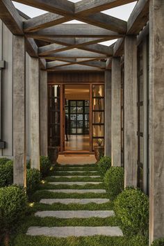 an entrance to a house with stone steps leading up to the front door and grass growing on the walkway