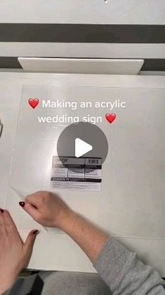 someone is making an acrylic wedding sign on the plane with their fingers and thumbnails