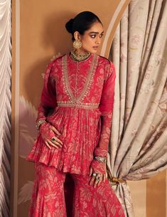 Illuminate your style in the royal fuchsia chiffon printed embroidered peplum and garara set. The peplum top, adorned with vibrant prints and intricate embroidery, exudes a striking and sophisticated allure. Paired with a matching garara that features a graceful flared silhouette, and complemented by a delicate net dupatta, this ensemble offers a perfect blend of bold color and refined elegance, making it ideal for any special occasion. Ridhi Mehra, Kurta Patterns, Gown Skirt, Embroidered Crop Tops, Floral Set, Floral Peplum, Sharara Set, Net Dupatta, Intricate Embroidery