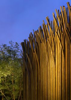 an artistic wooden sculpture in front of trees